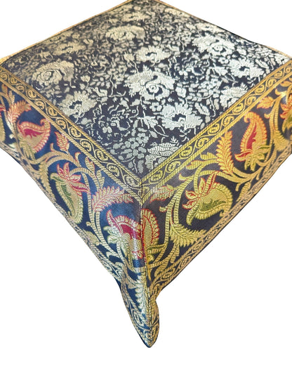 Noori Couture Banarasi brocade cushion cover with intricate gold zari floral motifs and paisley border in navy, red, and green.