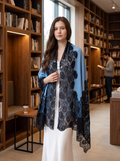Noori Couture blue Kashmiri wool shawl with intricate black Valentino lace trim draped over a white dress in a library
