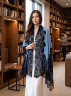 Noori Couture blue Kashmiri wool shawl with intricate black Valentino lace trim draped over a white dress in a library