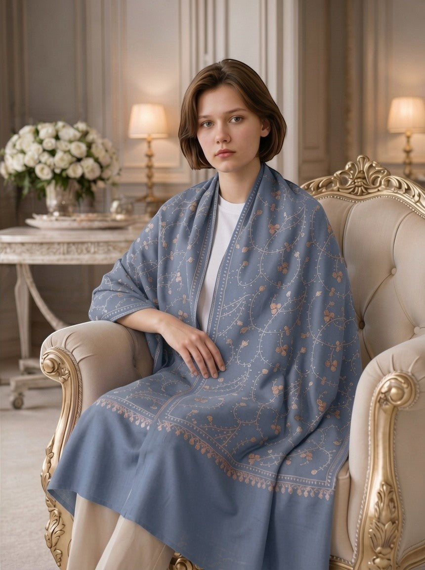 Noori Couture grey Merino wool shawl with intricate red Jali Sozni embroidery draped over a woman in a classic room.