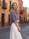 Noori Couture grey merino wool shawl with red Sozni embroidery worn by a woman on a cobblestone street