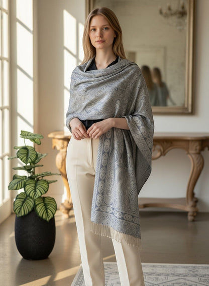 Noori Couture light grey pure silk shawl with intricate blue paisley pattern and fringed edges, worn by a model.