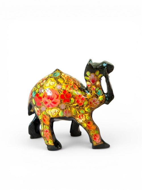 Noori Couture hand-painted camel figurine with vibrant floral patterns and glossy finish. Black base with red, pink, and yellow flowers.
