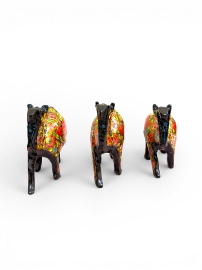 Noori Couture hand-painted black camel figurines with vibrant floral patterns and glossy finish.