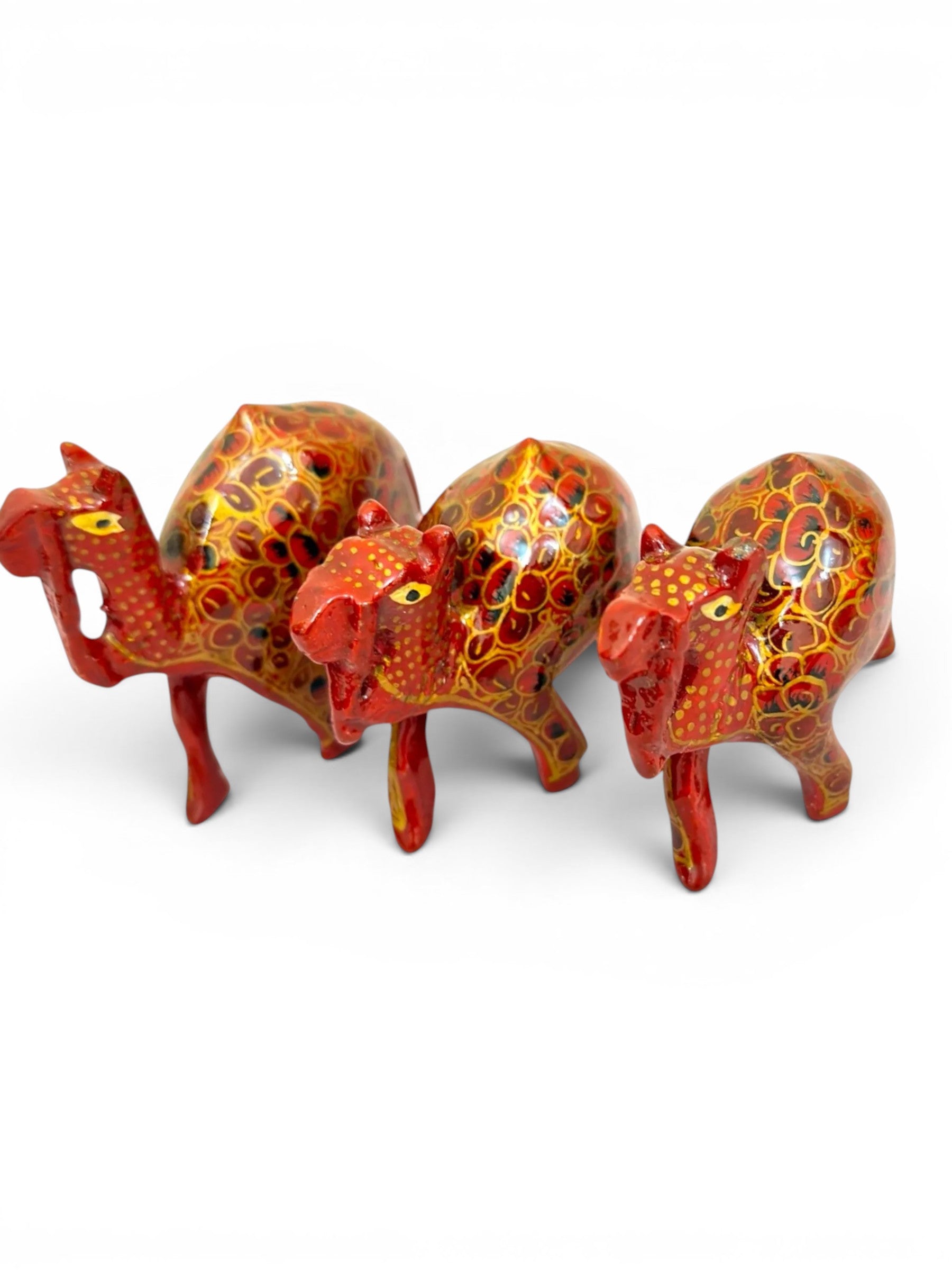 Noori Couture set of 3 hand-painted red and gold papier-mâché camel figurines with floral detailing.