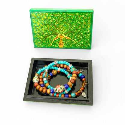 Noori Couture hand-painted green papier-mâché box with yellow and gold tree and birds design. Black interior.