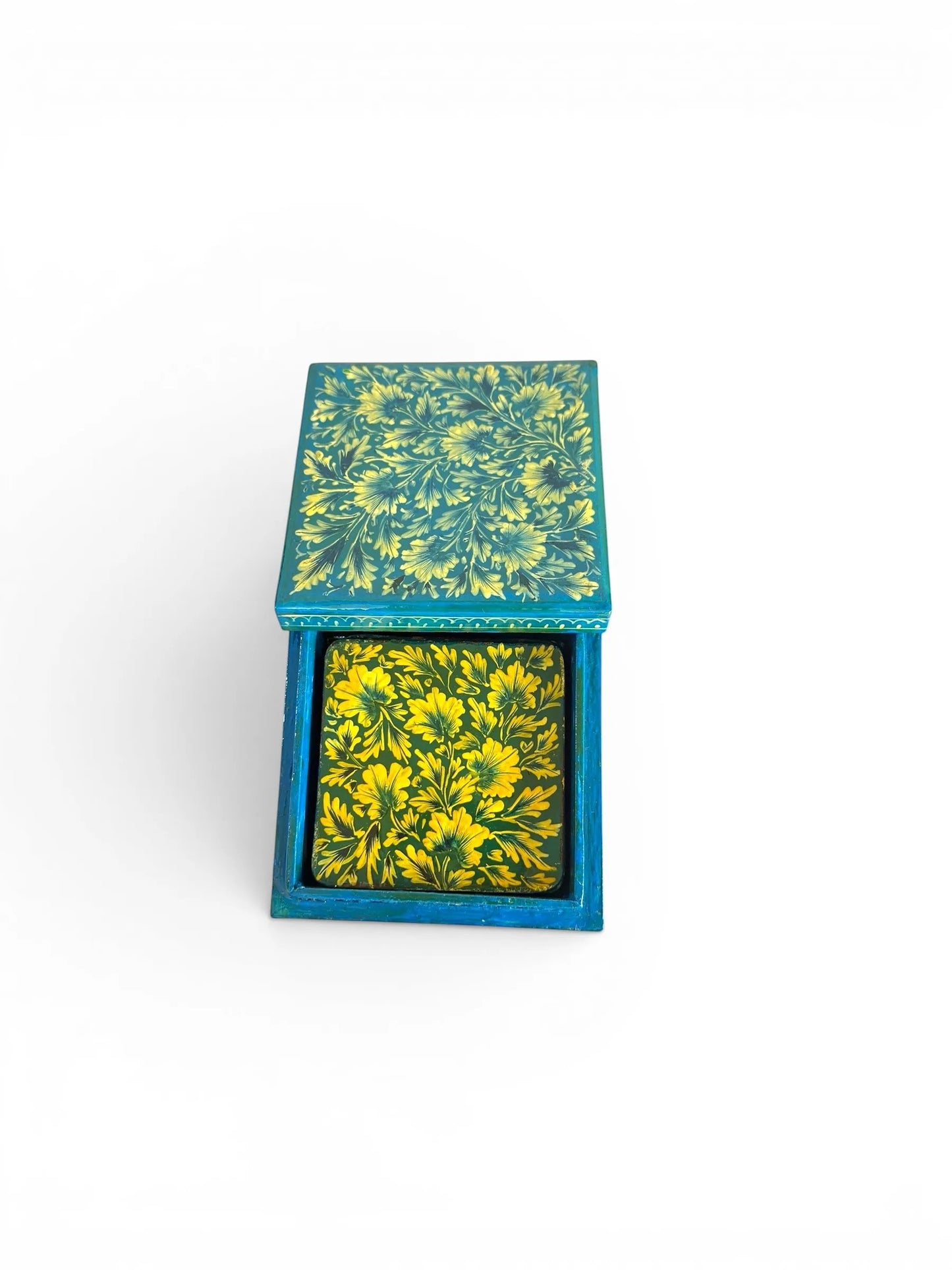 Noori Couture hand-painted papier-mâché coaster set with floral detailing in yellow and teal. Includes storage box.