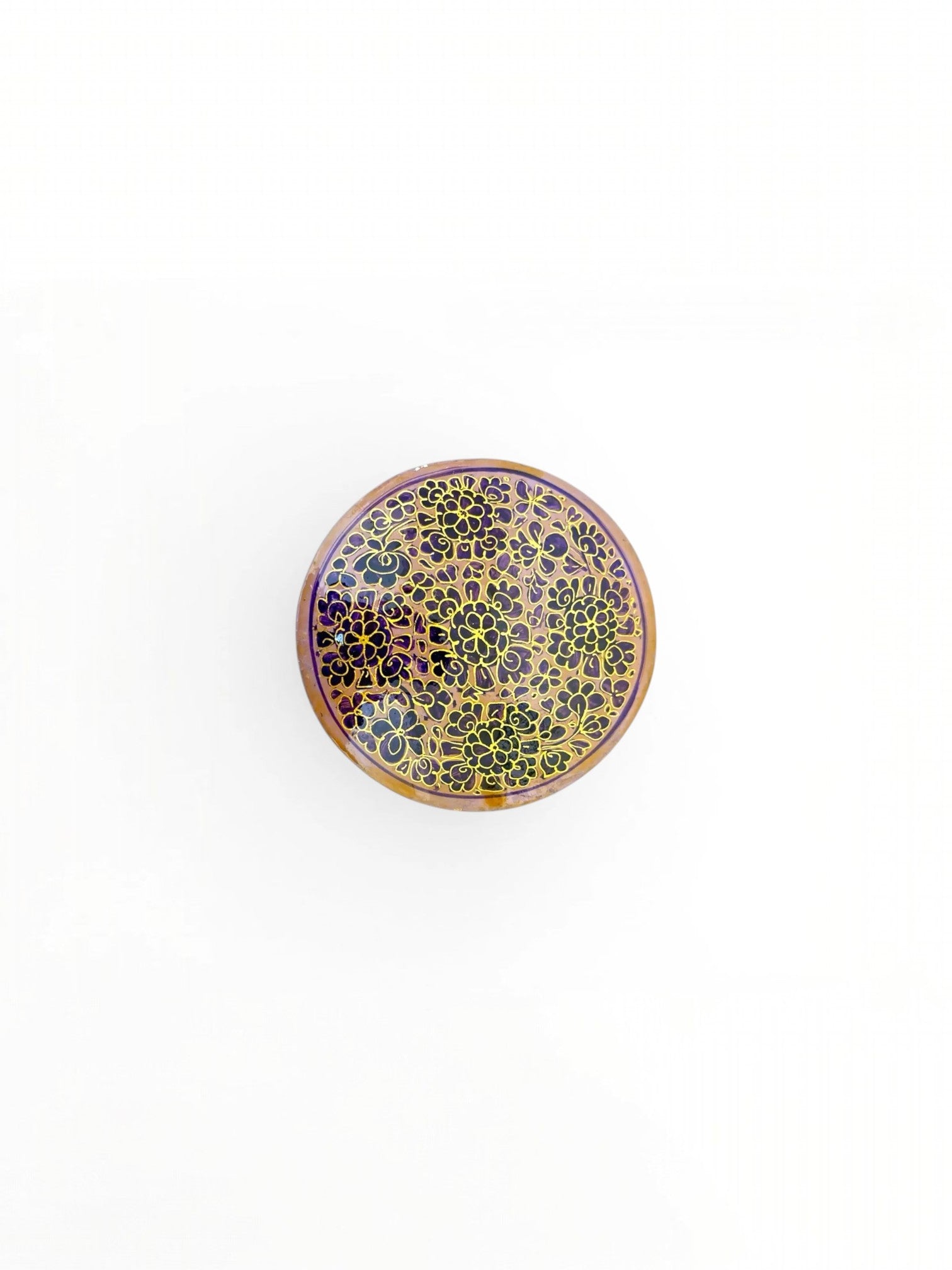 Noori Couture handpainted papier-mâché round coaster with intricate gold floral pattern on a purple background.