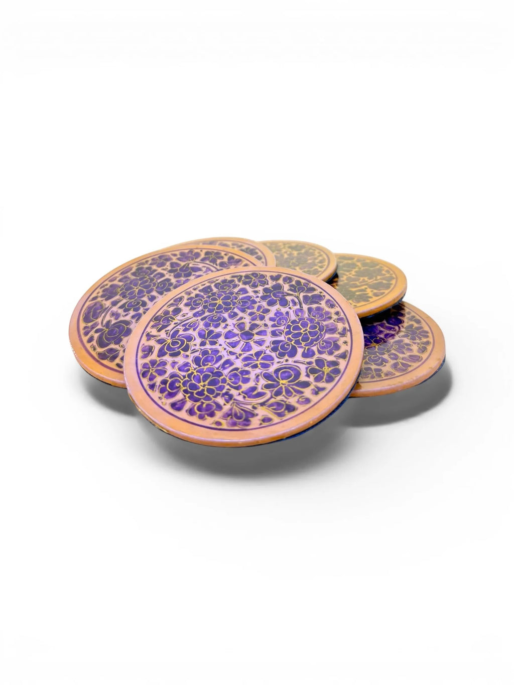 Noori Couture handpainted papier-mâché coasters with intricate floral patterns in purple and gold on a natural wood base.
