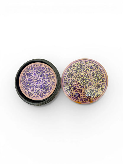 Noori Couture handpainted papier-mâché round coasters with intricate floral patterns in purple and gold.