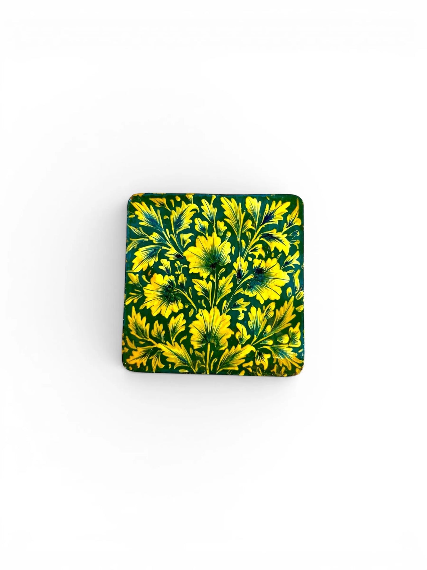 Noori Couture square papier-mâché coaster with hand-painted yellow floral design on a dark green background.
