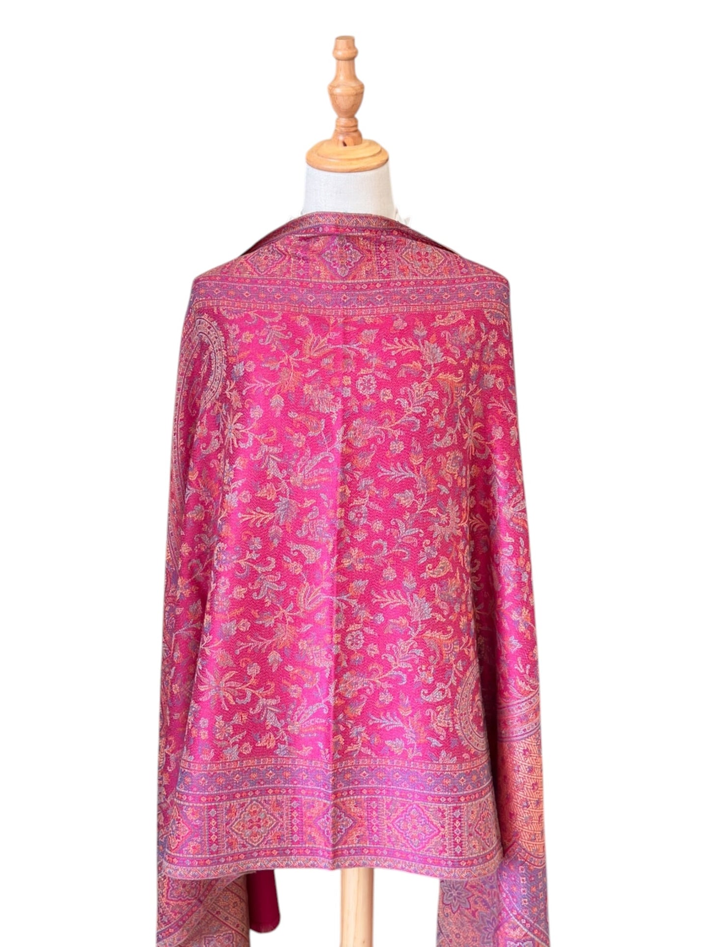 Noori Couture magenta pink shawl wrap with intricate traditional woven patterns and delicate fringe on a mannequin
