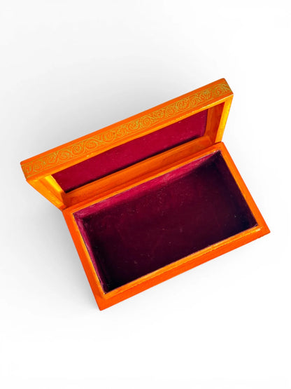 Noori Couture orange papier-mâché keepsake box with red velvet lining and gold decorative border.