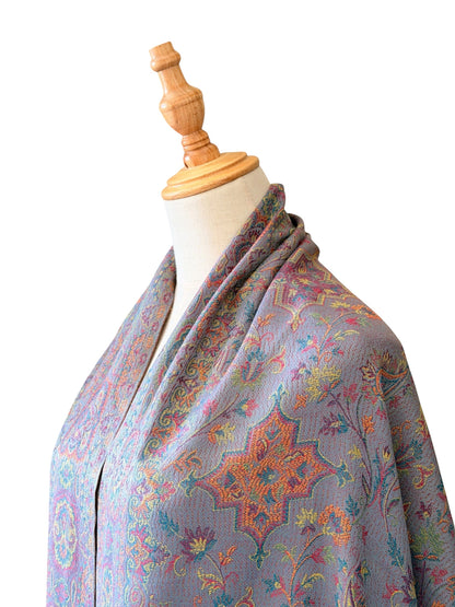 Noori Couture pashmina shawl in sea weed grey with intricate paisley patterns in coral, gold, and violet on a mannequin