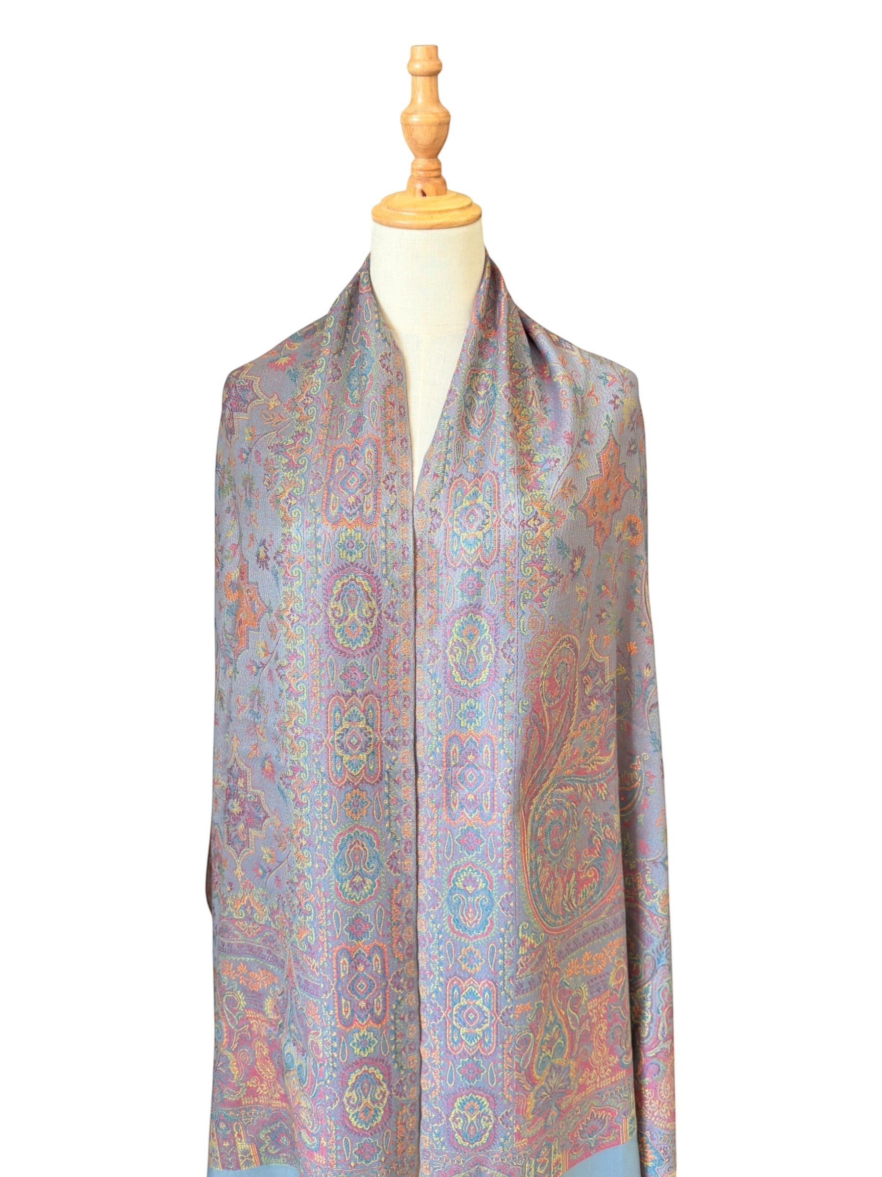 Noori Couture sea weed grey pashmina shawl with intricate paisley pattern in coral, gold, and violet on a mannequin.