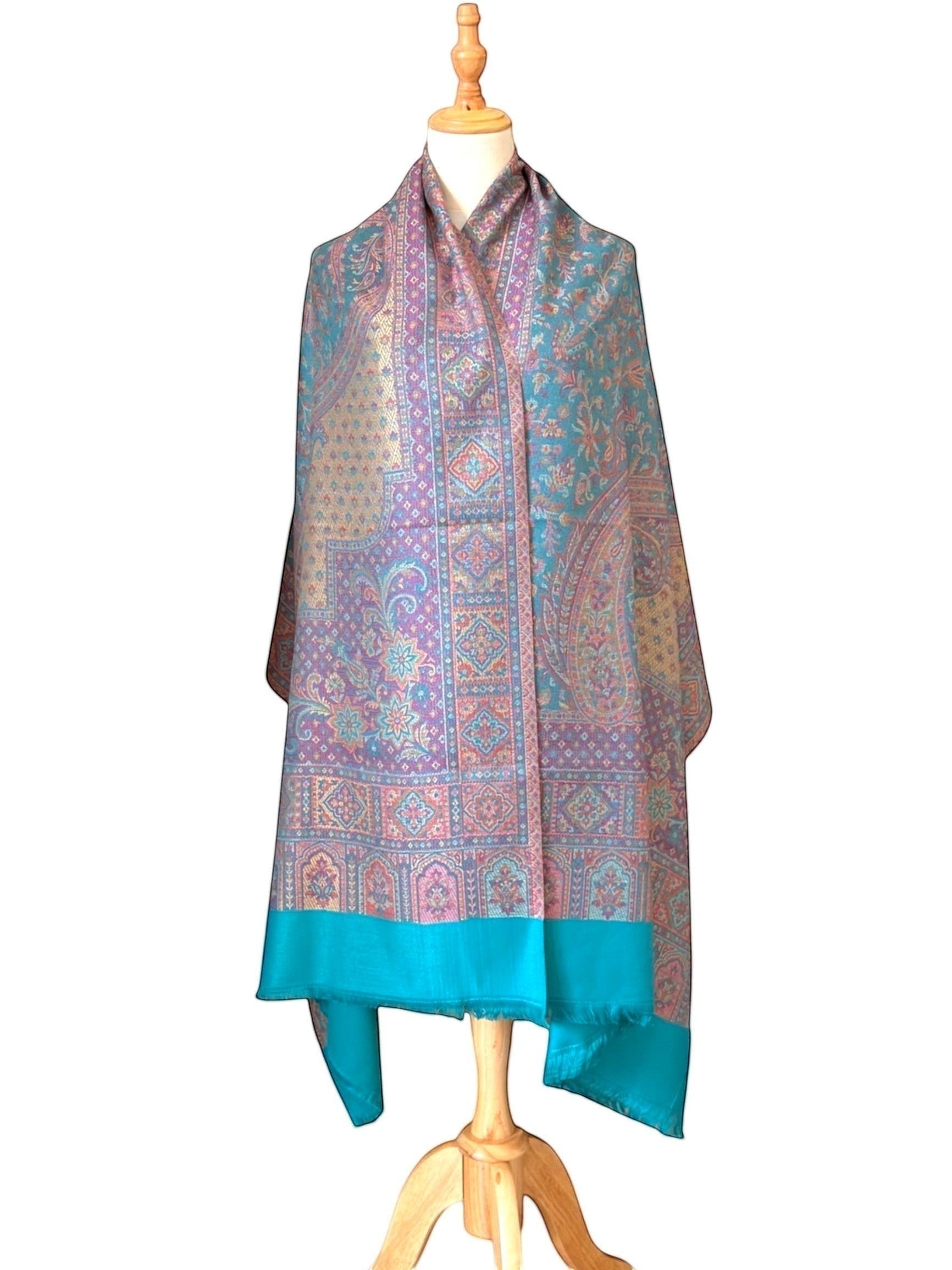 Noori Couture pashmina shawl with intricate teal, violet, and gold paisley patterns and a delicate fringed hem.
