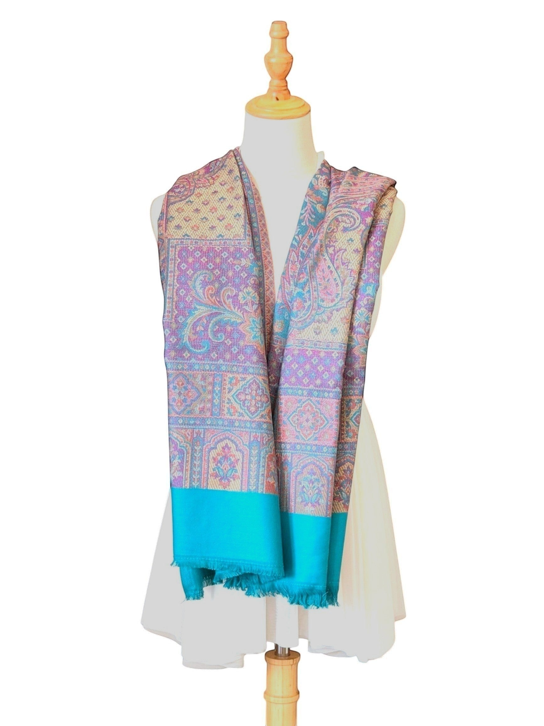 Noori Couture pashmina shawl featuring intricate teal, violet, and gold paisley patterns with a delicate fringed hem.