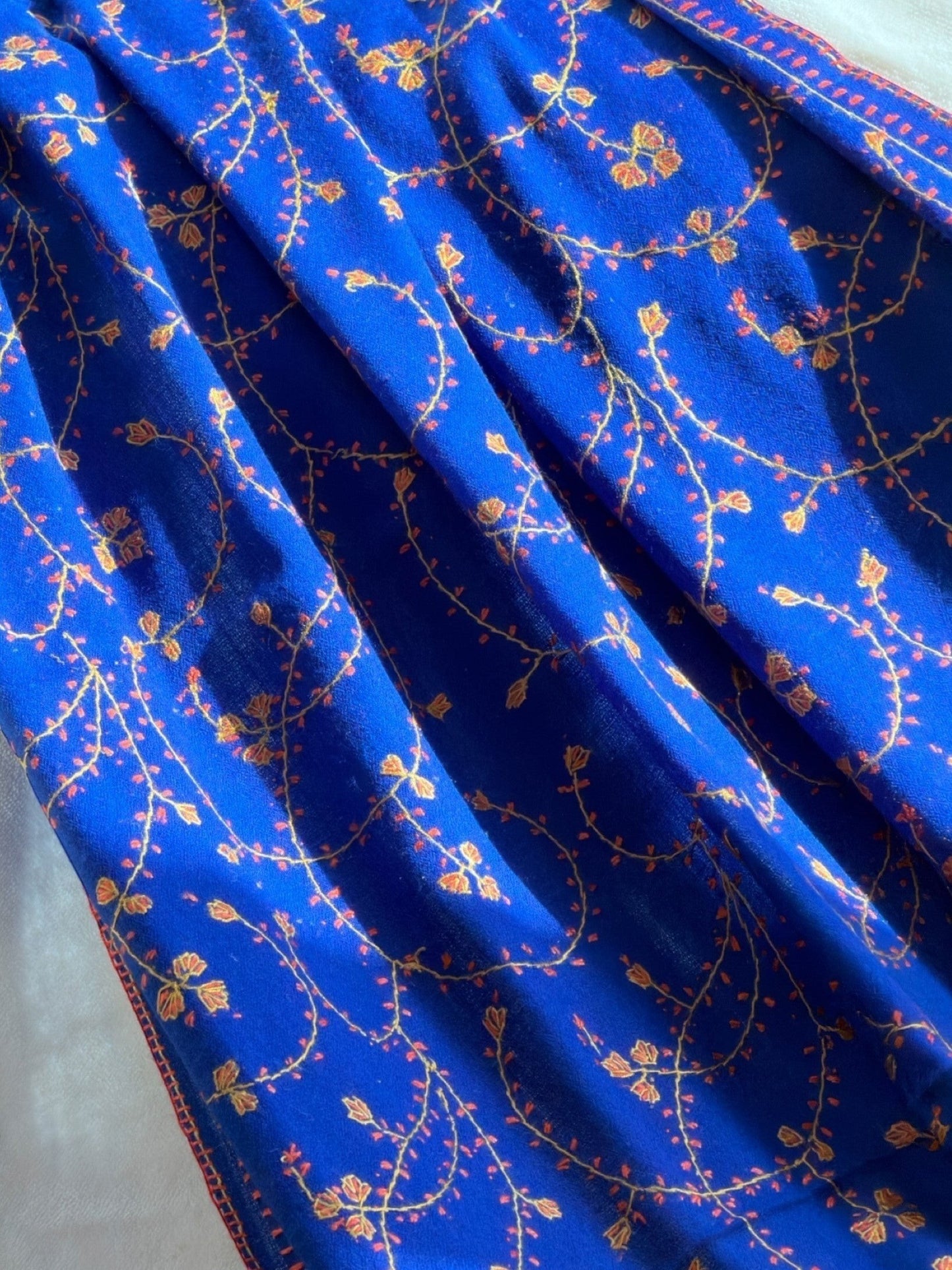 Noori Couture royal blue handwoven shawl with intricate Sozni Jali embroidery in yellow and orange floral vine pattern.