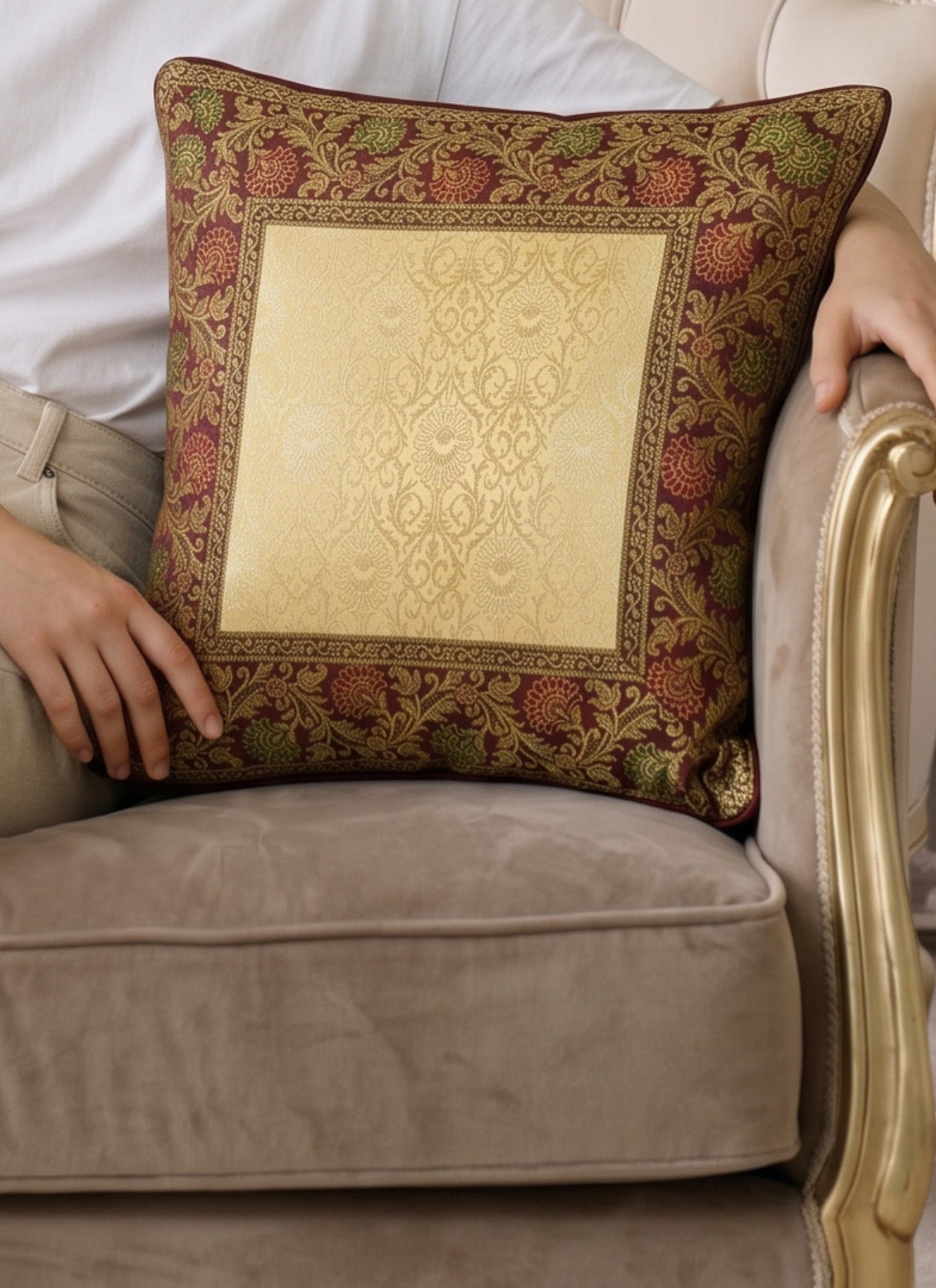 Noori Couture Royal Cushion Cover in gold brocade with intricate zari detailing and floral motifs in burgundy and green.
