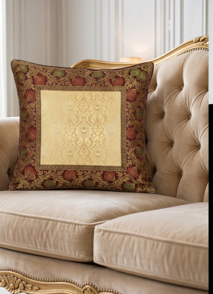Noori Couture Royal Cushion Cover in gold brocade with intricate zari detailing and floral motifs in burgundy and green.