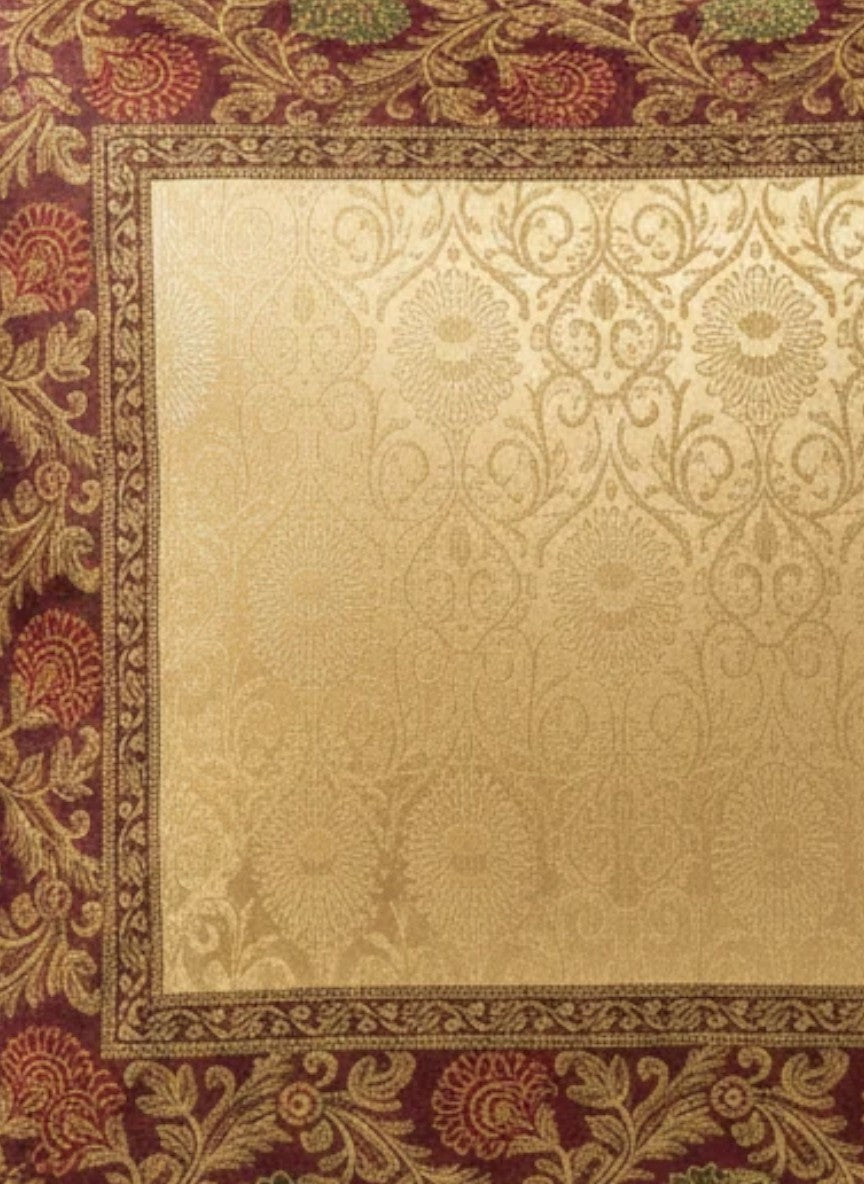 Noori Couture Royal Cushion Cover in gold brocade with intricate zari detailing and floral motifs in red and green.