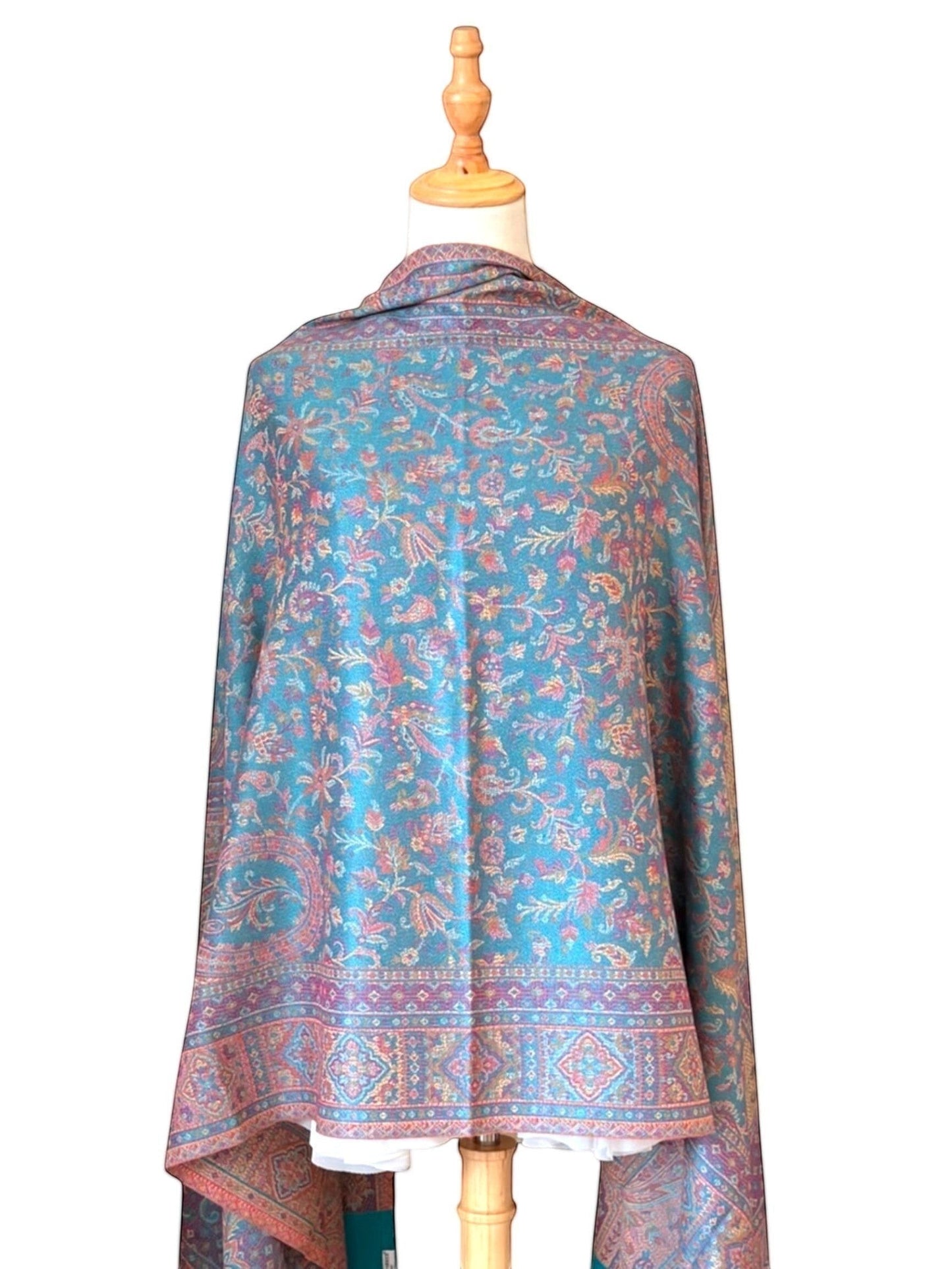 Noori Couture pashmina shawl in teal with intricate violet and gold paisley and geometric patterns and fringed hem.