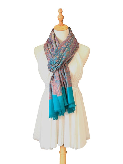 Noori Couture pashmina shawl with intricate teal and violet paisley patterns and fringed hem on a mannequin