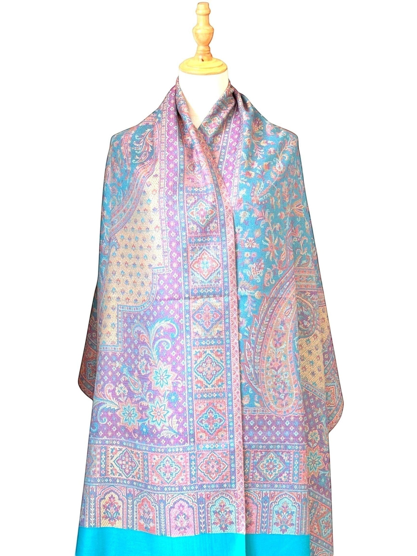 Noori Couture pashmina shawl featuring intricate teal, violet, and gold paisley and geometric patterns with fringe hem.